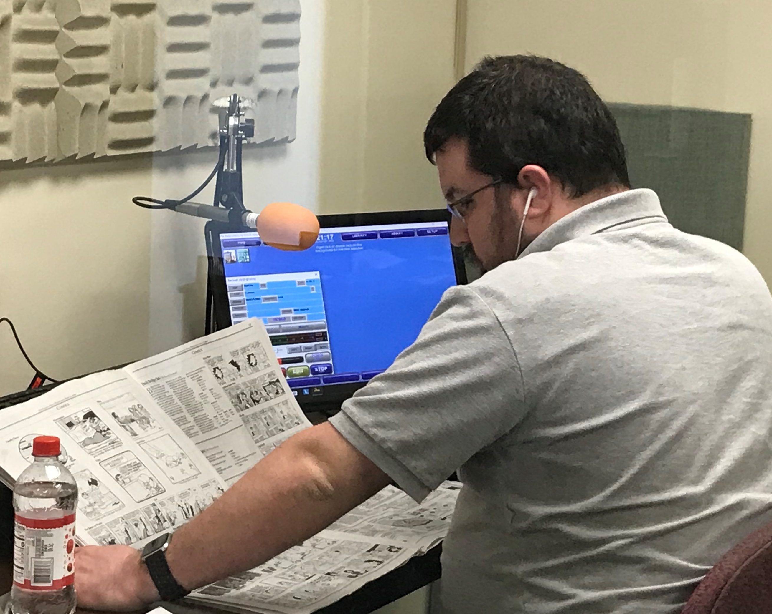 Photo shows a reader recording the comic section from a recent issue of the Buffalo News.
