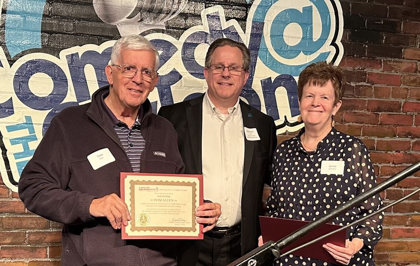 Tom Allen holding a certificate, Mike Benzin and Ginni Jurkowski