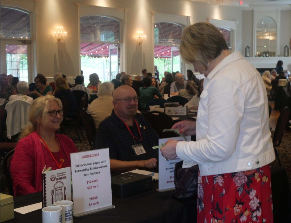 An attendee buys raffle tickets from two staffers